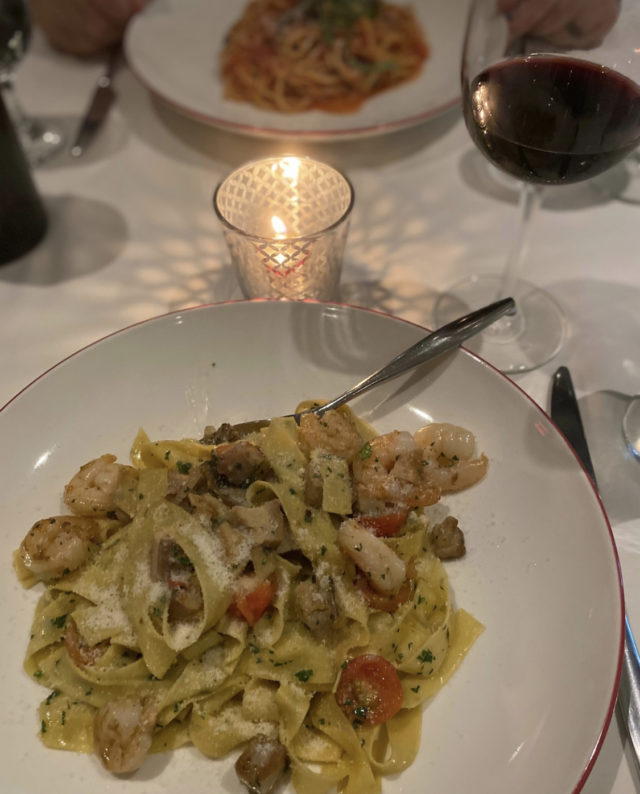 A plate of handmade pasta on a candlelit table.